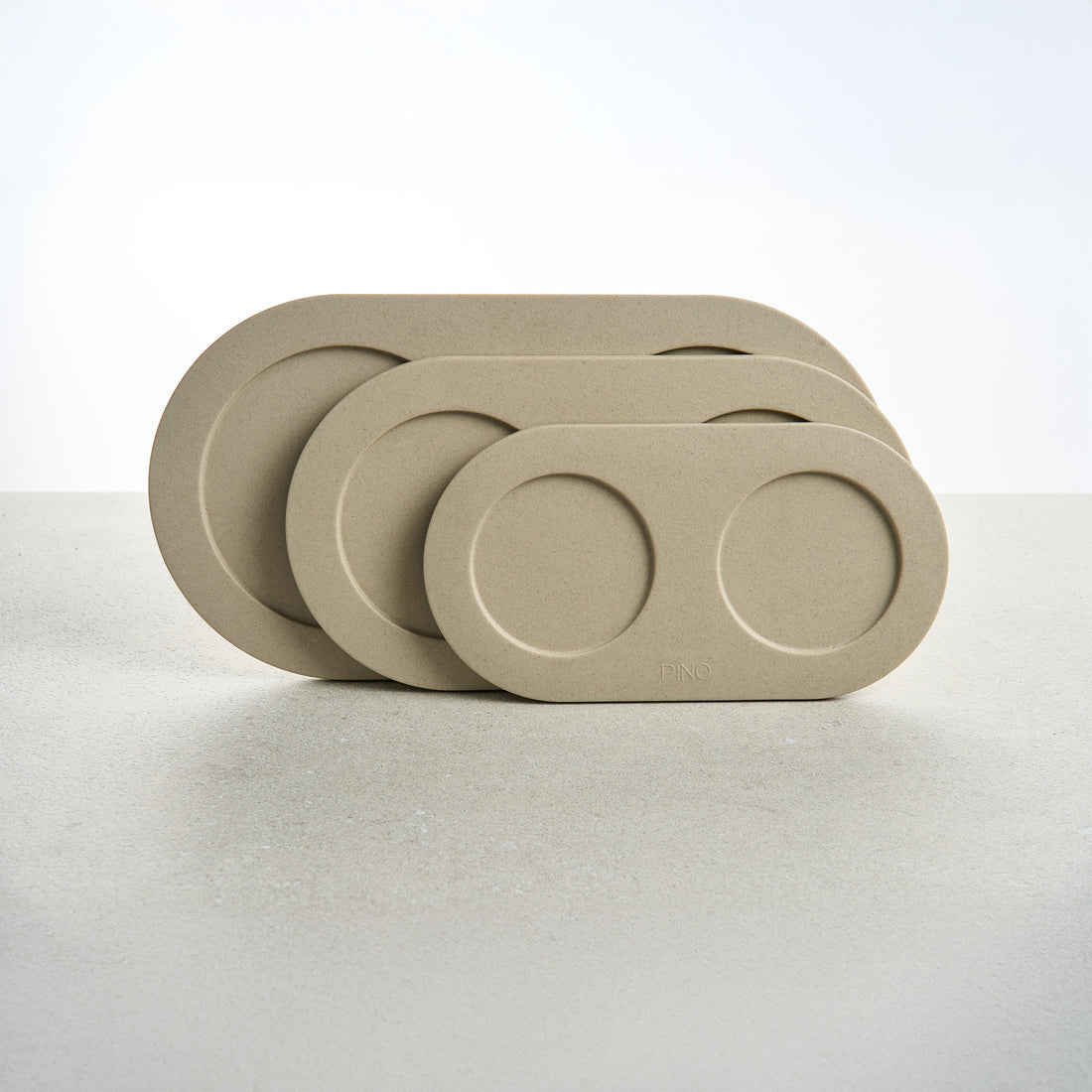 Drie PINO Plateaus in Small, Medium en Large, rechtop gestapeld, in beige