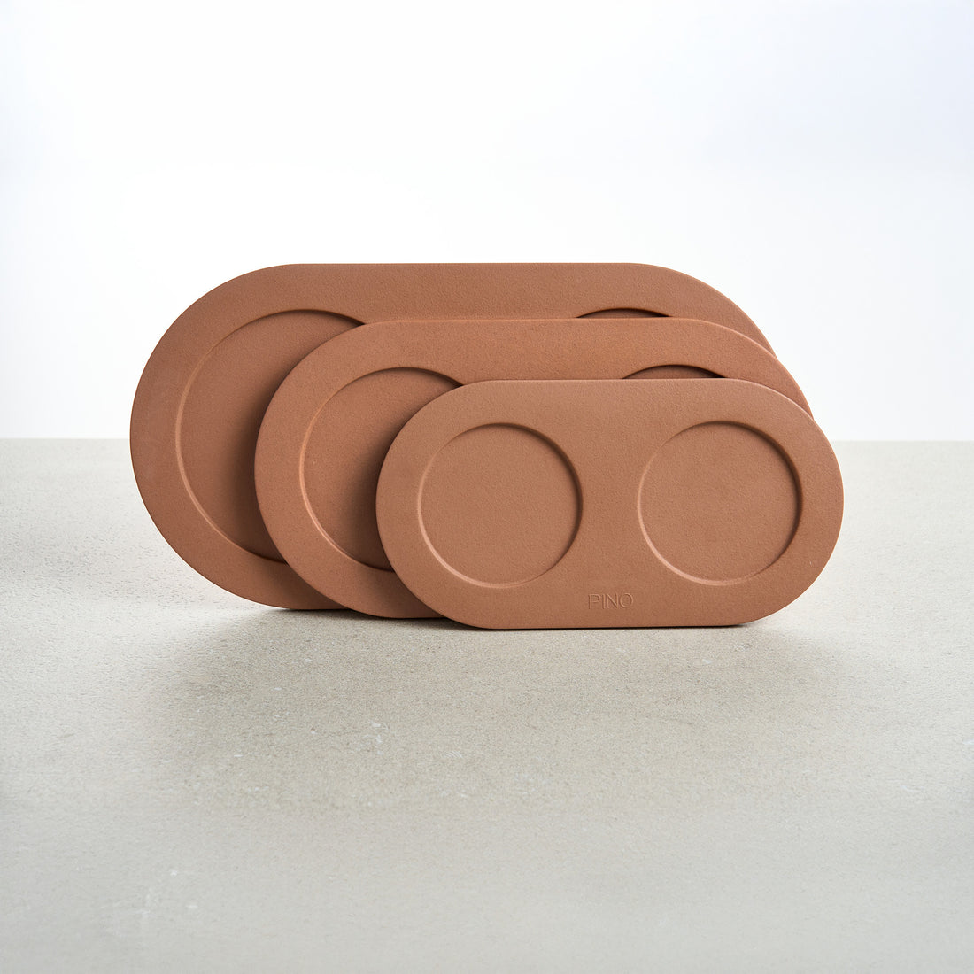 Drie PINO Plateaus in Small, Medium en Large, rechtop gestapeld, in terracotta
